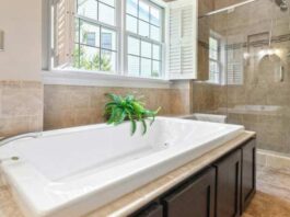 Туш или када: шта је практичније за породицу и мали простор Bela ugradna kada sa zelenom biljkom pored prozora i staklenim tušem