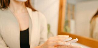 Колико грађани годишње троше на козметику и личну негу Osoba maže belu kremu po prstima ispred ogledala