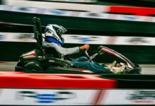 Где потражити мало адреналина када вам досаде класични изласци? Osoba sa kacigom vozi kart pored crveno-bele zaštitne ograde trkačke staze