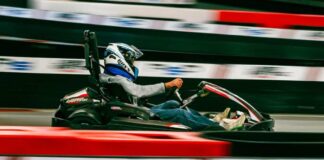 Где потражити мало адреналина када вам досаде класични изласци? Osoba sa kacigom vozi kart pored crveno-bele zaštitne ograde trkačke staze