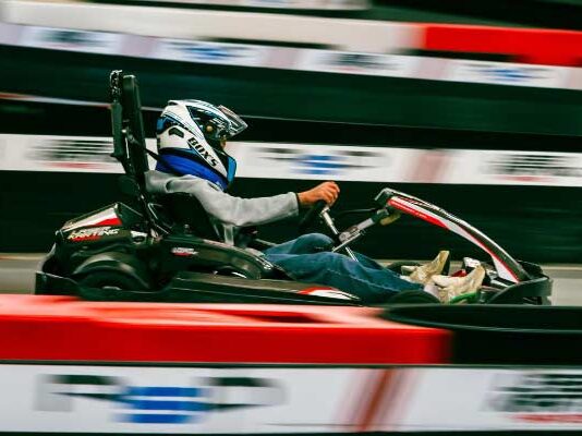 Где потражити мало адреналина када вам досаде класични изласци? Osoba sa kacigom vozi kart pored crveno-bele zaštitne ograde trkačke staze